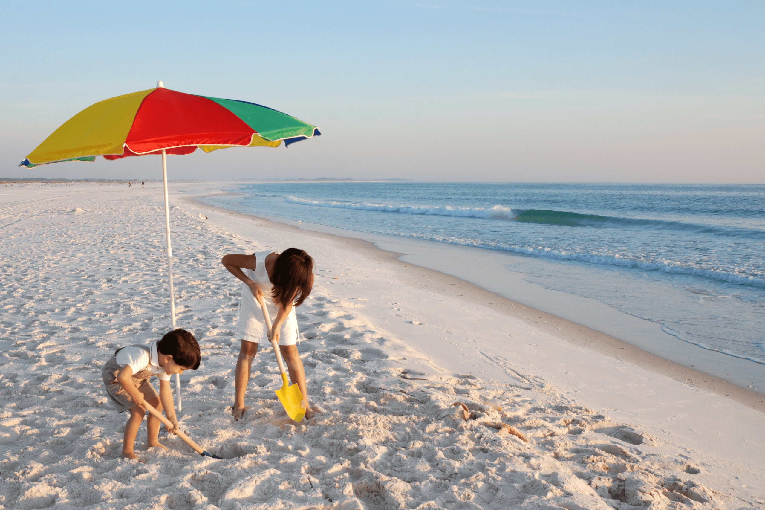 Griechenland mit Kindern am Strand unter einem Sonnenschirm mit Meerblick
